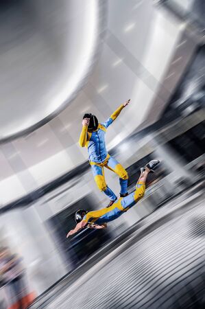 Adrenaline. Extreme sky for free people. No rules in open air. Parachutist in blue and orange suit is in free fall. Skydiving is a sport of the future.の写真素材