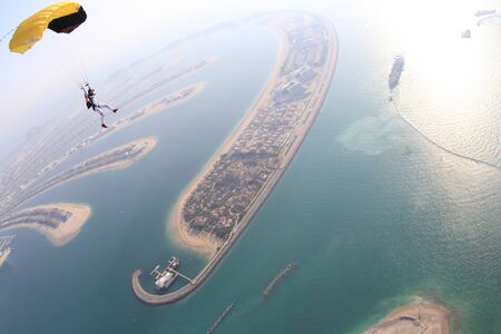 Activity. Men with parachute equipment have wings. Skydiver is flying in open air. Parachutist in blue suit is in free fall. No gravitation in sky.の写真素材