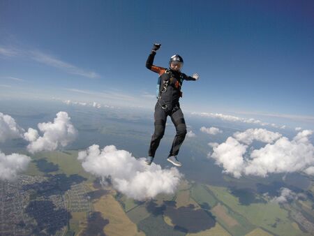 Up. Fly men is a pilot of his body in air. Extreme people prefer skydiving. Parachutist in black suit. Free lifestyle.の写真素材
