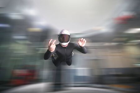 Two finfers. Men in parachute shows two fingers. Gesture by fingers. Skydiving sport.の写真素材