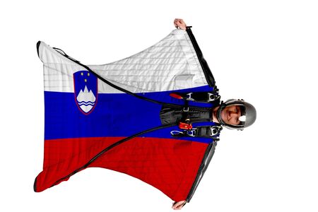 Slovenia flag. Men in wing suit templet. Skydiving men in parashute. Simulator of free fall.の写真素材