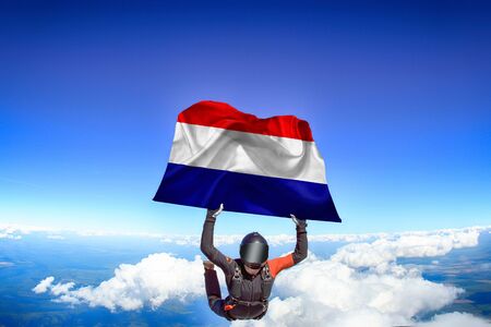 Netherlands extreme. Flag in skydiving. People in free fall grab flag of Netherlands. Patriotism, men and flag.の写真素材