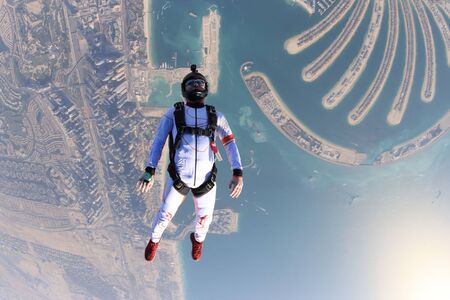 Jump. Extreme people prefere sky sport. Fly men perfoms trick in air. Parachutist in white suit is in free fall. Skydiving is sport without rules.の写真素材