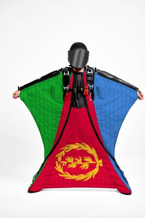 Eritrea flag travel. Simulator of free fall. Men in wing suit.の写真素材