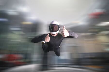 Gesture of approval. Men in parachute shows class by finger. Gesture by fingers. Skydiving sport.の写真素材