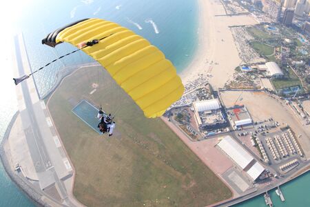 Activity. Men with parachute equipment have wings. Skydiver is flying in open air. Parachutist in blue suit is in free fall. No gravitation in sky.の写真素材