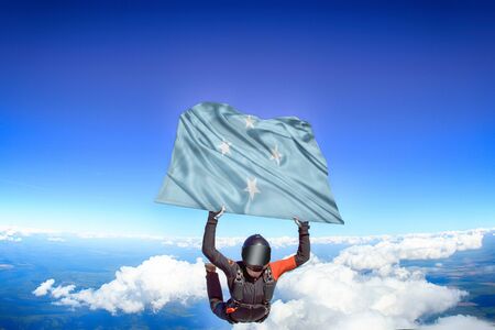Federated States of Micronesia extreme. Flag in skydiving. People in free fall grab flag of Federated States of Micronesia. Patriotism, men and flag.の写真素材