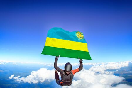 Rwanda extreme. Flag in skydiving. People in free fall grab flag of Rwanda. Patriotism, men and flag.の写真素材