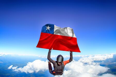 Chile extreme. Flag in skydiving. People in free fall grab flag of Chile. Patriotism, men and flag.の写真素材