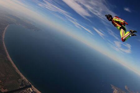 Pilot. Extreme sky for free people. No rules in open air. Parachutist in yellow suit is in free fall. Skydiving is a sport of the future.の写真素材