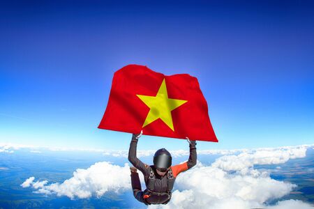 Vietnam extreme. Flag in skydiving. People in free fall grab flag of Vietnam. Patriotism, men and flag.の写真素材