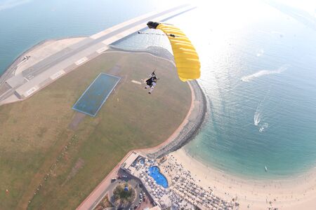 Landing. Extreme sky for free people. No rules in open air. Parachutist in white suit is in free fall. Skydiving is a sport of the future. の写真素材