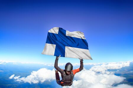 Finland extreme. Flag in skydiving. People in free fall grab flag of Finland. Patriotism, men and flag.の写真素材