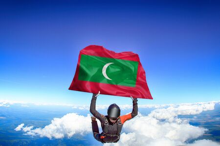Maldives extreme. Flag in skydiving. People in free fall grab flag of Maldives. Patriotism, men and flag.の写真素材