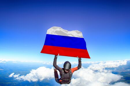 Russia extreme. Flag in skydiving. People in free fall grab flag of Russia. Patriotism, men and flag.の写真素材