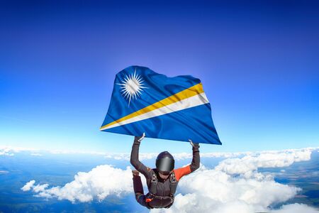 Marshall Islands extreme. Flag in skydiving. People in free fall grab flag of Marshall Islands. Patriotism, men and flag.の写真素材