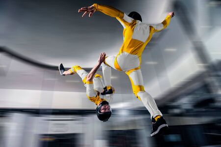Risk. Brave men in parachute equipment. Skydiving is sport for extreme people. Flyer in white and yellow suit. The sky without borders.の写真素材