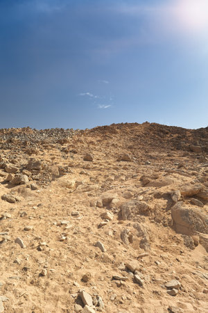 Hillside with rocks in dry desert. Egypt hot lifeless sand and rock mountain and blue sky in summer sunny day. Travel and tourism concept.の写真素材