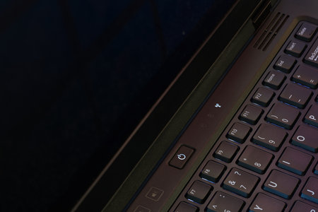Illuminated power button and part of keyboard of laptop. Closeup view.の写真素材