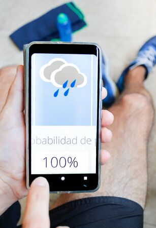 Sport equipment and man looking at weather forecastの写真素材