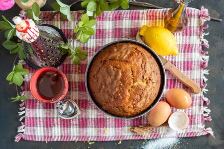 Homemade sponge cake and its ingredients, flour, eggs, sugar, olive oil, cinnamon and lemonの写真素材