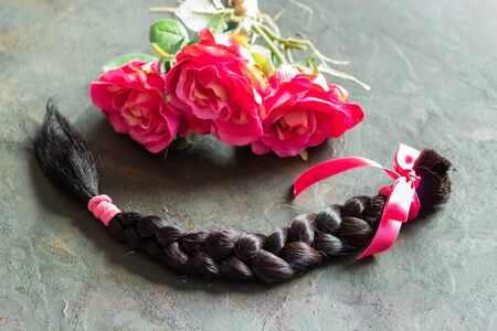 Brown hair braid on pink background for hair donation for women with cancer chemotherapy