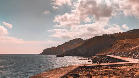 Rocky coast of Ceuta under sky with clouds
