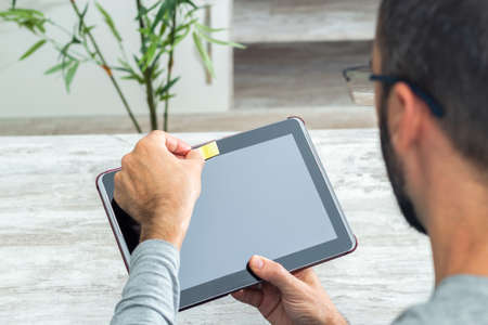 Man covering the camera of the tablet with a paper