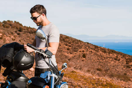 Biker putting on helmet in the field