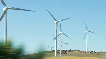 Wind generators spinning in operation viewed from a moving car
