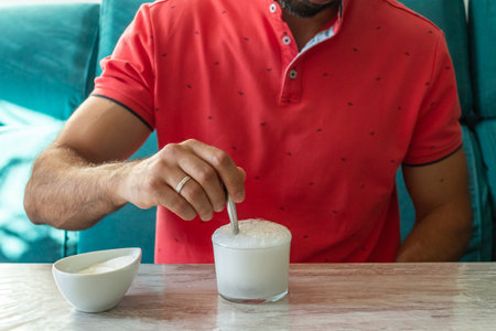 Caucasian man with stomach ache preparing fruit saltの写真素材