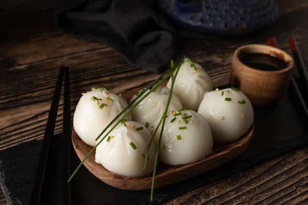 Steamed pork and prawn dim sum on slate stone on wooden tableの写真素材