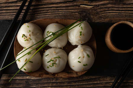 Steamed pork and prawn dim sum on slate stone on wooden table