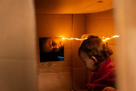 Mother and daughter playing with a cardboard boxの写真素材