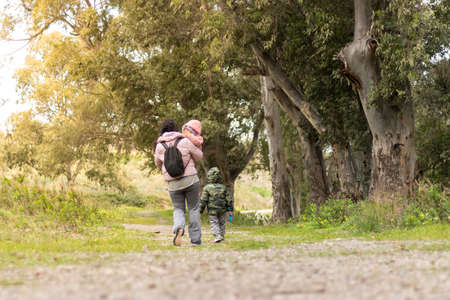 Mother and children walking in the field, unrecognizableの写真素材