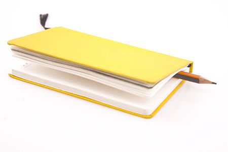 yellow notebook and pencil on  white backgroundの写真素材