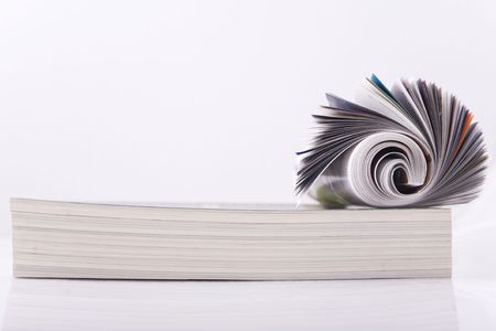 Magazine Roll isolated on white, on a bunch of other magazinesの写真素材