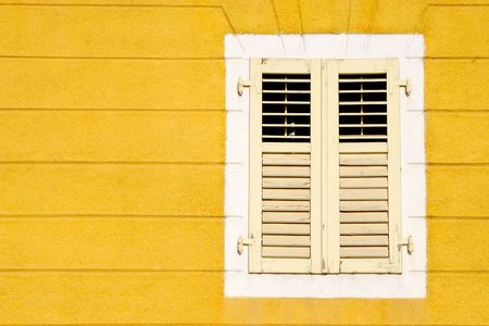 Yellow wall an and wooden windowの写真素材