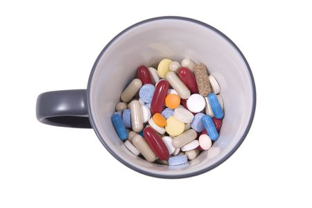 front view from cup of multicolored tablets and capsulesの写真素材