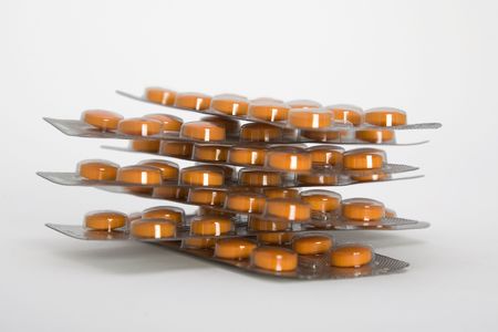 Packs of orange pills isolated on white background.