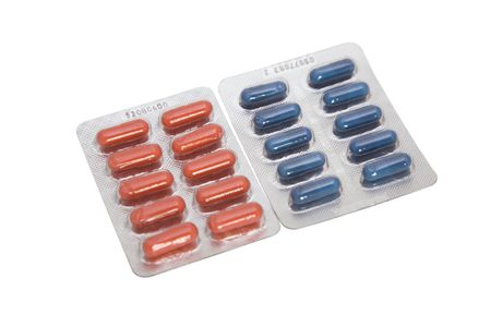 two blister with red and blue pills on white background