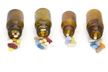 colored stream of pills coming from a pill bottles - on a white backgroundの写真素材