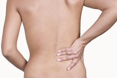 Woman massaging lower pain back, isolated on white background 