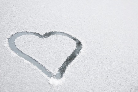 Heart shape drawn on white snow, love symbol for Valentine Day の写真素材