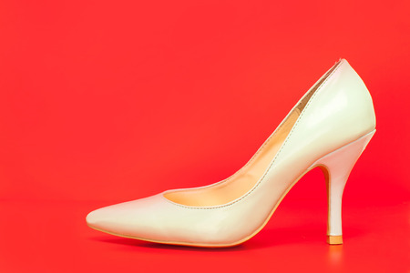 side view of white high heels shoes on red backgroundの写真素材