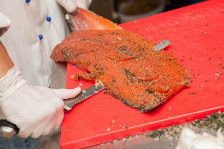 Chef Cutting salmon fish and preparing sushi