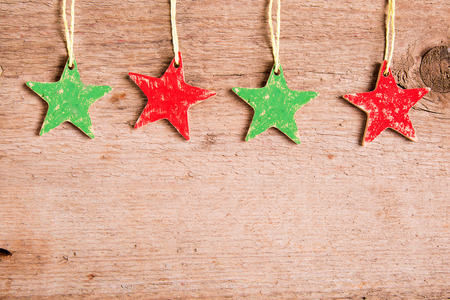 christmas card with red and green stars on wooden backgroundの写真素材