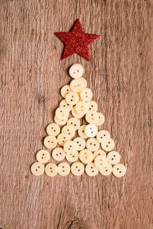 White buttons as decorative Christmas tree on wooden vintage backgroundの写真素材