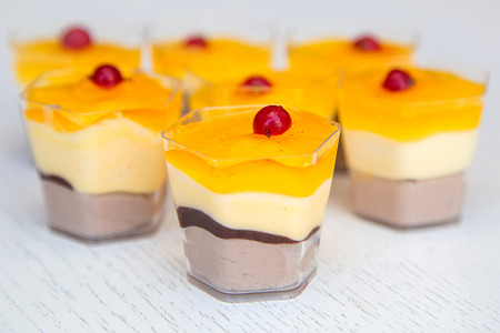yellow mini cake with red cranberries on wooden backgroundの写真素材