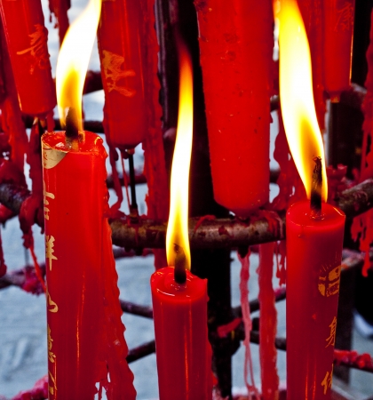 Burning red candles in a Buddha templeの写真素材